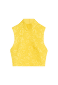 Cropped yellow sleeveless top with flower detailing. Set against a checkered background. 