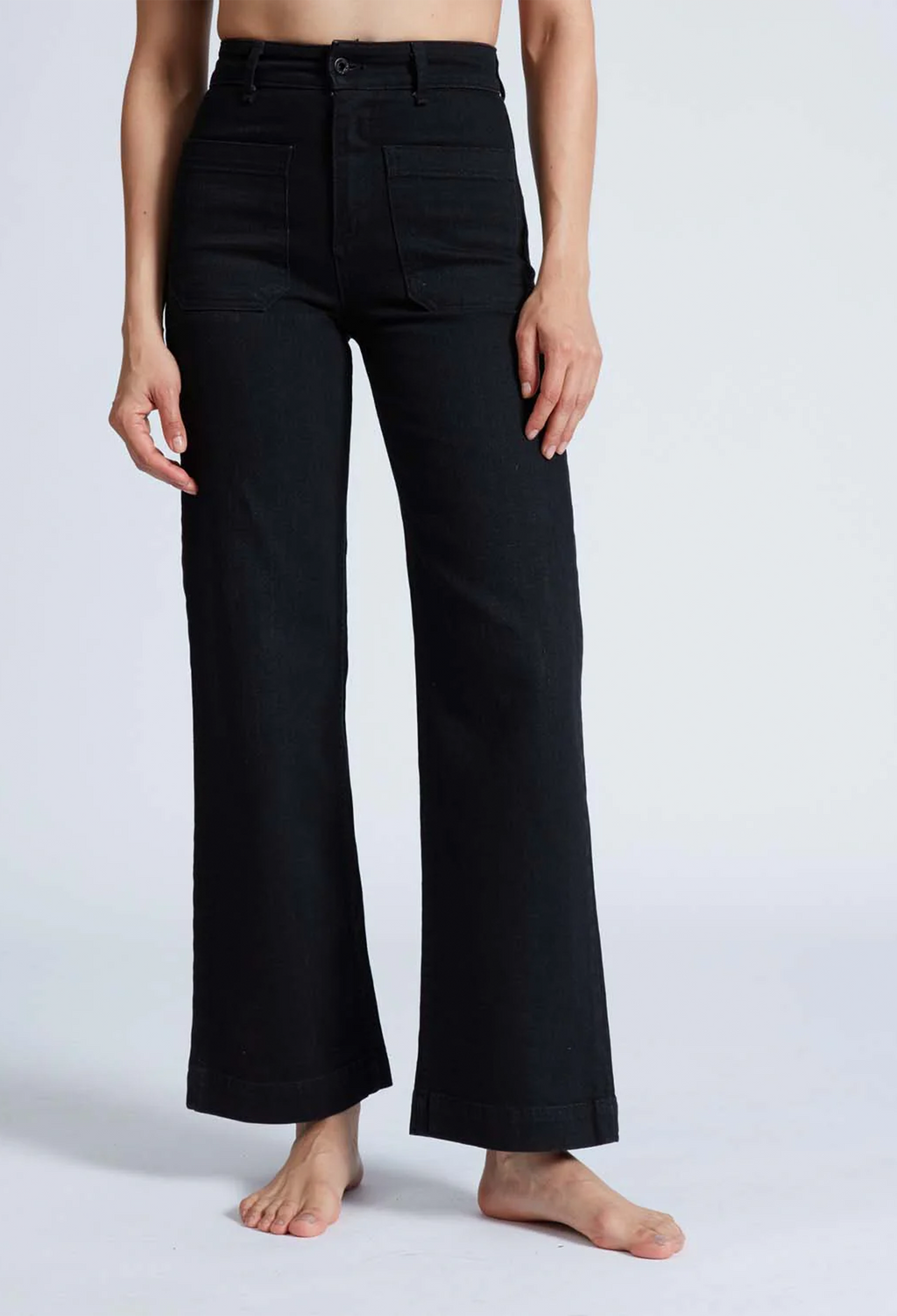 Model wears high rise wide leg black jeans. 