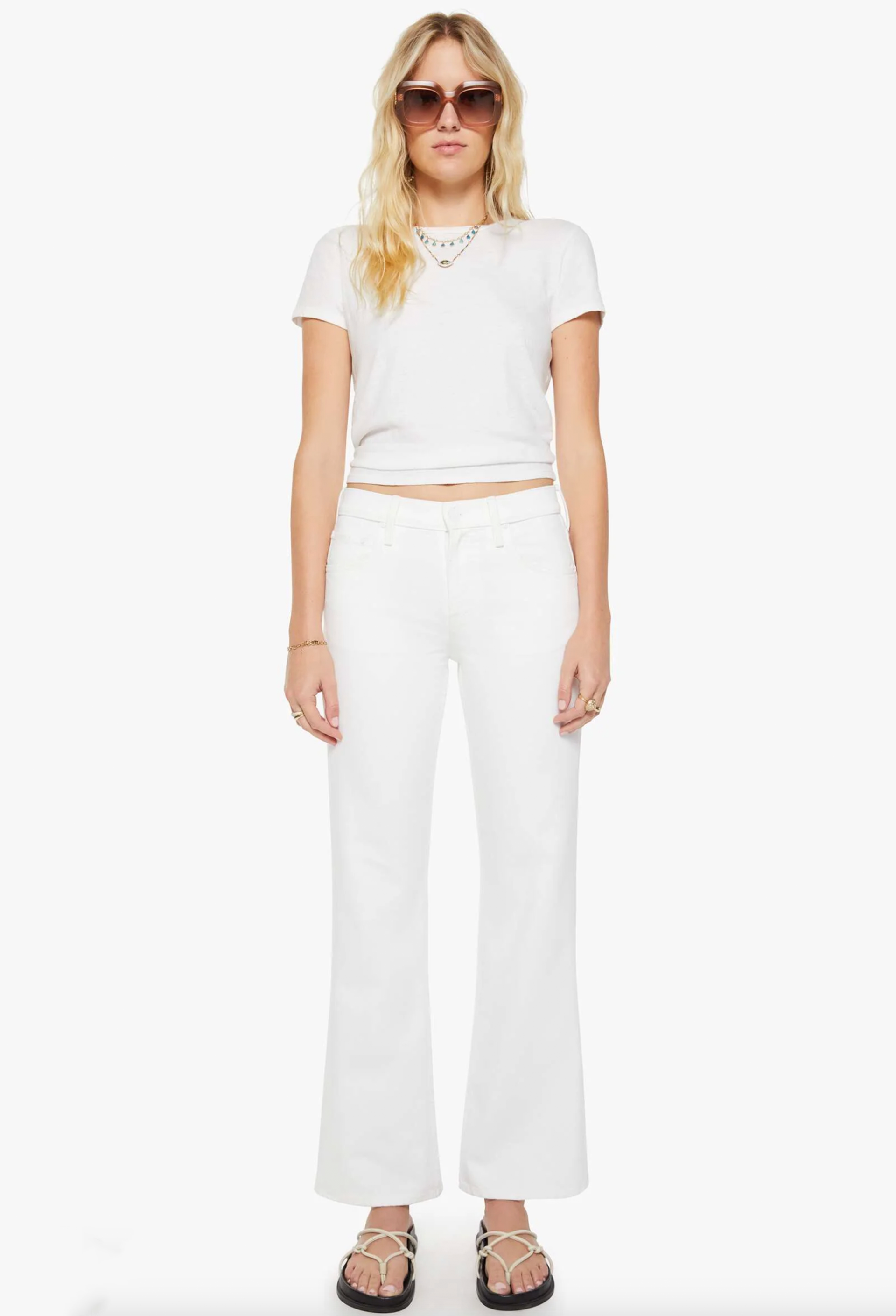 Woman wearing a white outfit with sunglasses on a white background