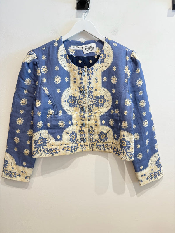 Blue Bandana Print jacket on a white hanger hanging on a white wall.