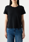 Person wearing a black t-shirt and blue jeans on a plain background