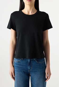 Person wearing a black t-shirt and blue jeans on a plain background