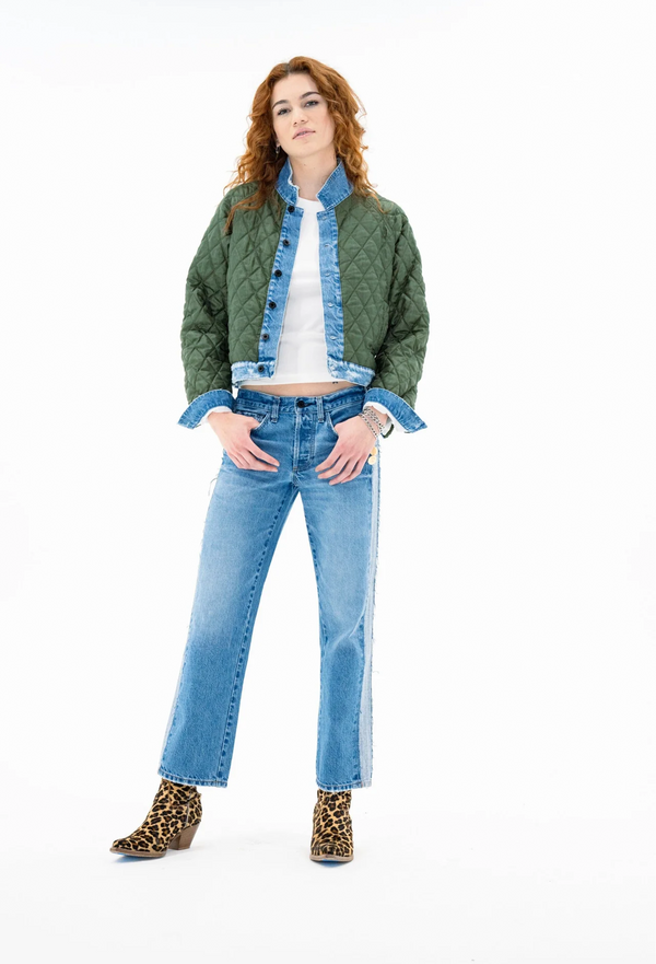 Woman wearing a green jacket, white shirt, blue jeans, and leopard print boots on a white background