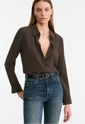 Woman wearing a brown blouse and high-waisted blue jeans on a white background