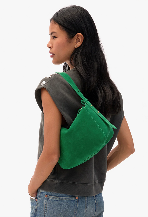 Person wearing a green shoulder purse on a white background
