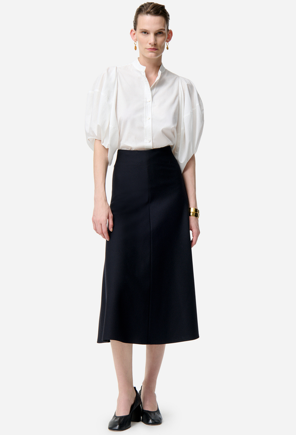 Person wearing a white blouse and black skirt on a white background