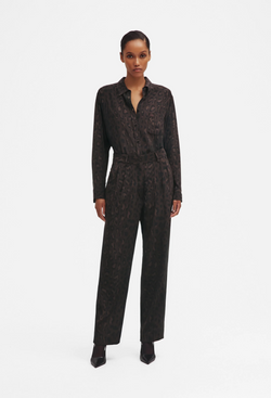 Woman wearing a leopard patterned shirt and pants on a white background