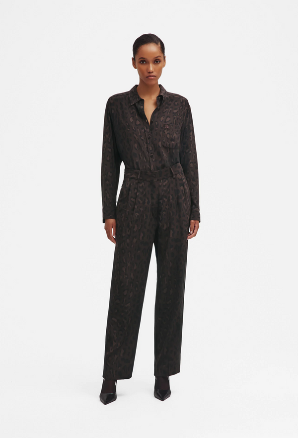 Woman wearing a leopard patterned shirt and pants on a white background