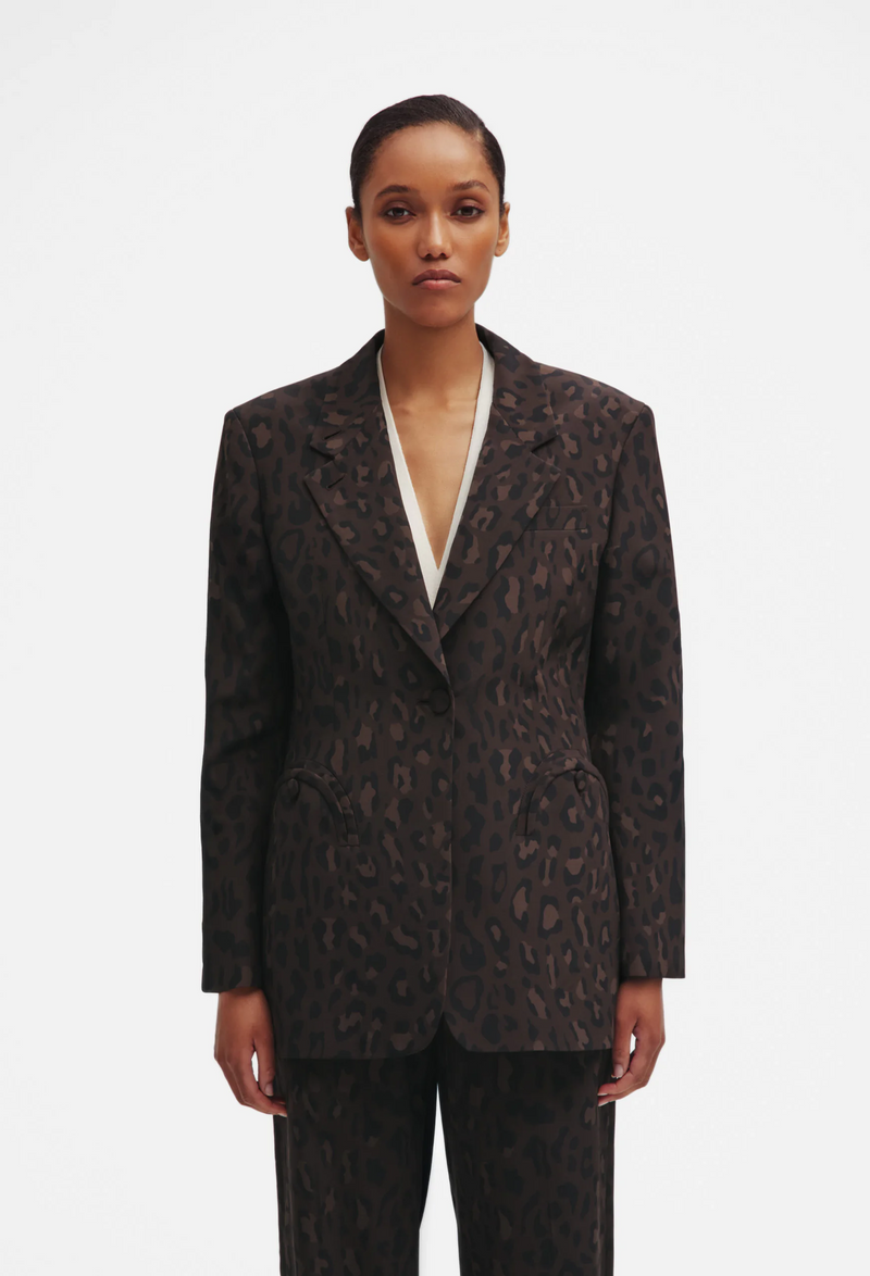 Woman wearing a leopard patterned blazer on a white background