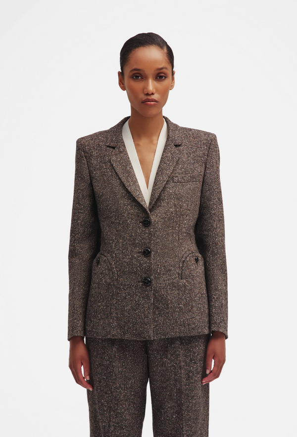 Woman wearing a brown suit with a white shirt on a white background
