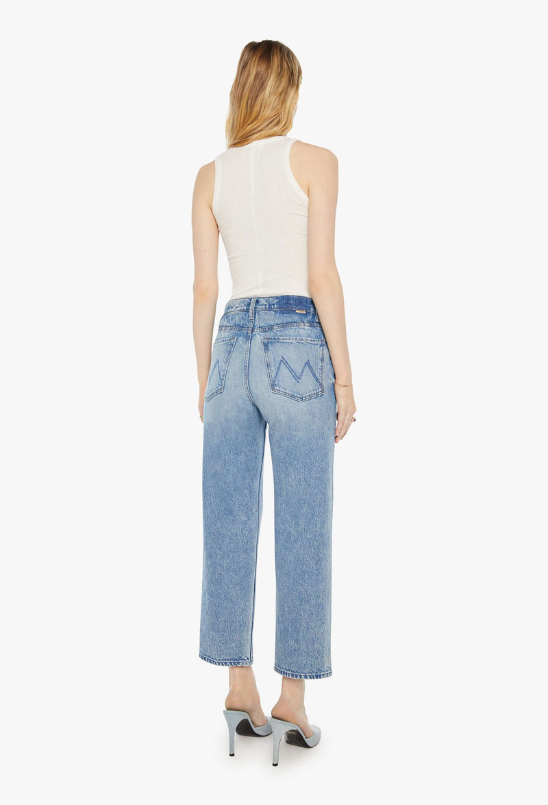 Woman wearing light blue jeans and a white sleeveless top on a white background