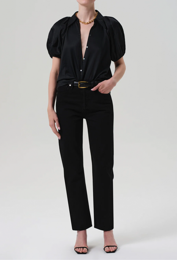 Person wearing a black top and jeans with a belt on a white background