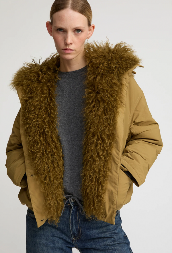 Person wearing a brown jacket with a fur-lined hood on a white background
