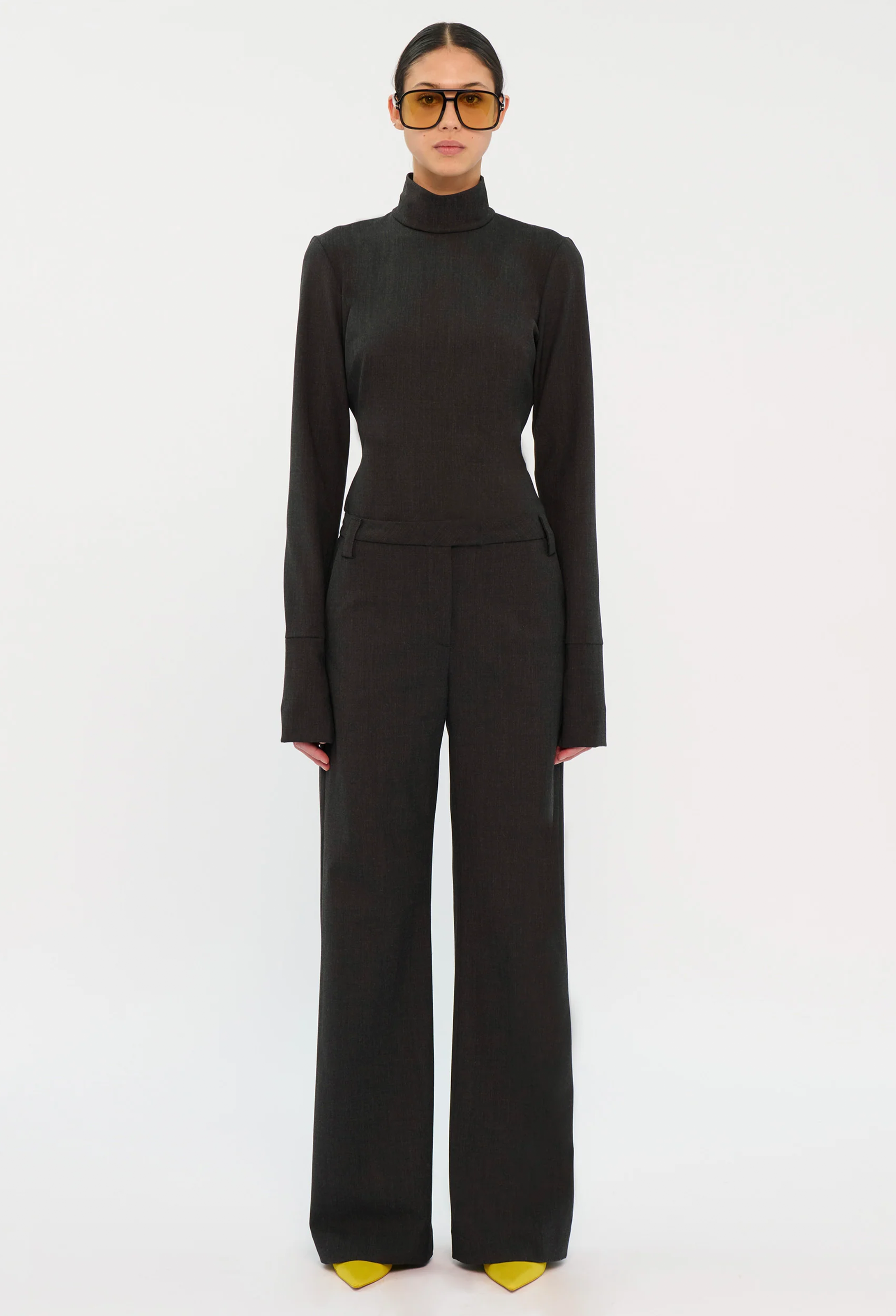 Person wearing a black turtleneck and pants on a white background