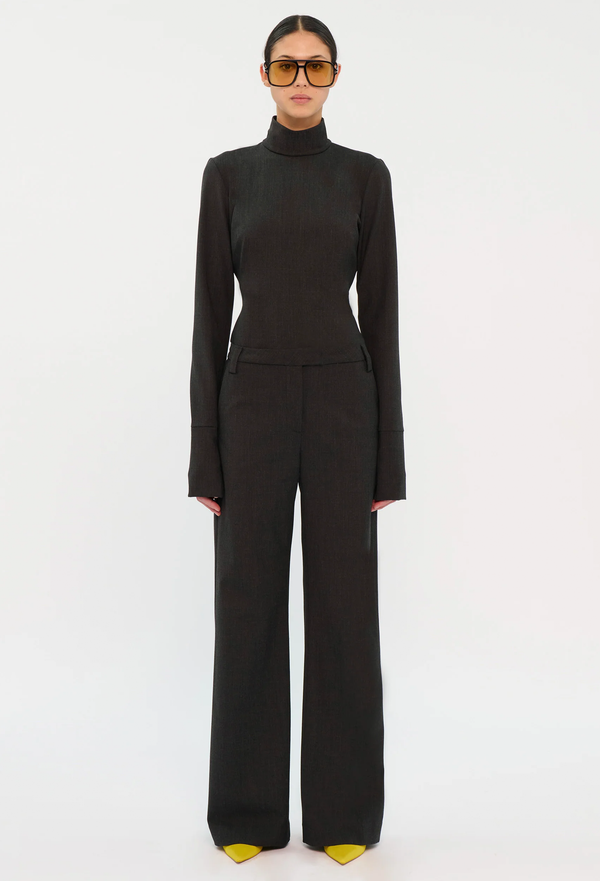 Person wearing a black turtleneck and pants on a white background