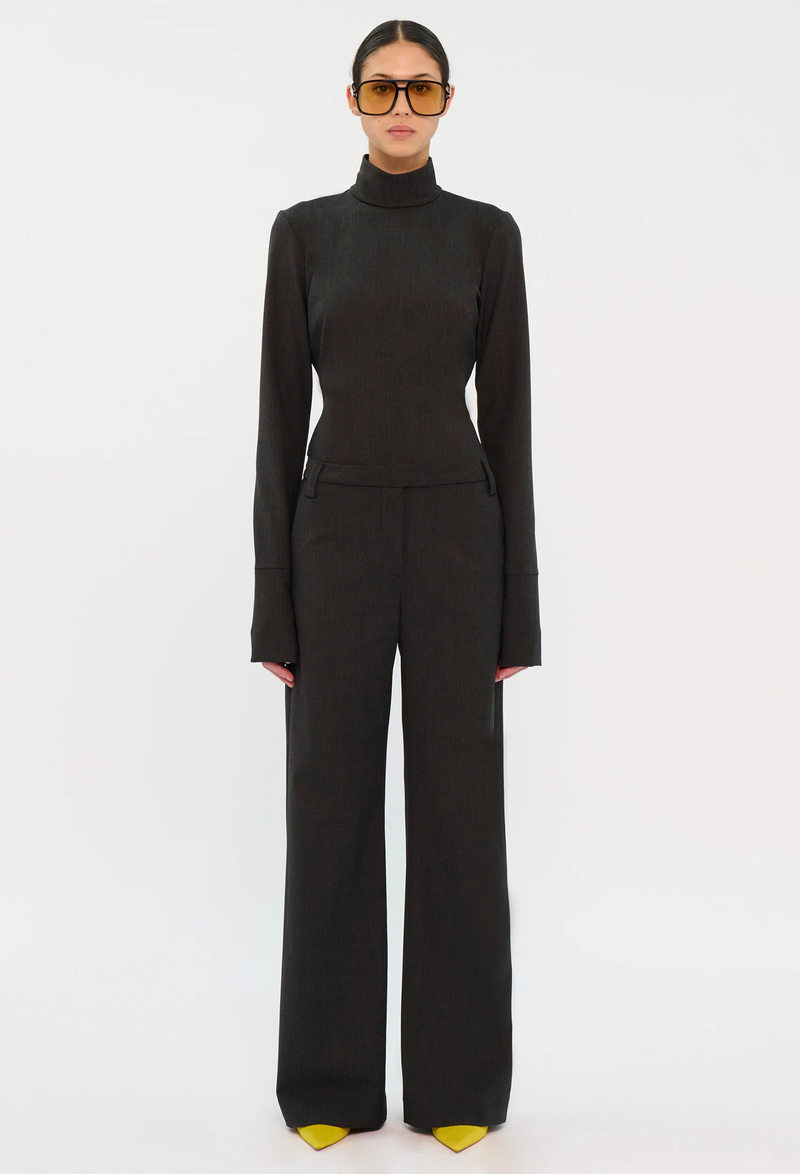 Person wearing a black turtleneck and pants on a white background