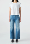 Person wearing a white t-shirt and blue jeans on a plain background