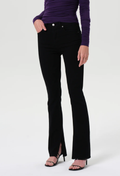 Person wearing black flared jeans and a purple top on a white background