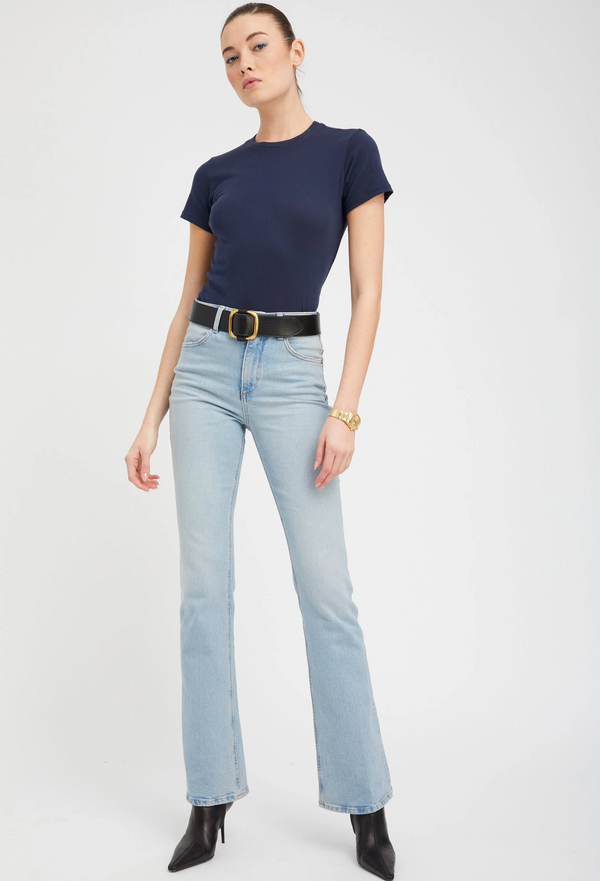 Person wearing a navy blue t-shirt and light blue jeans on a white background