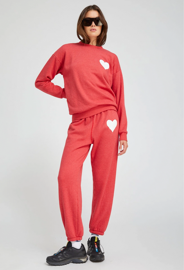 woman wearing a red heart sweatshirt and matching sweatpants on a white background