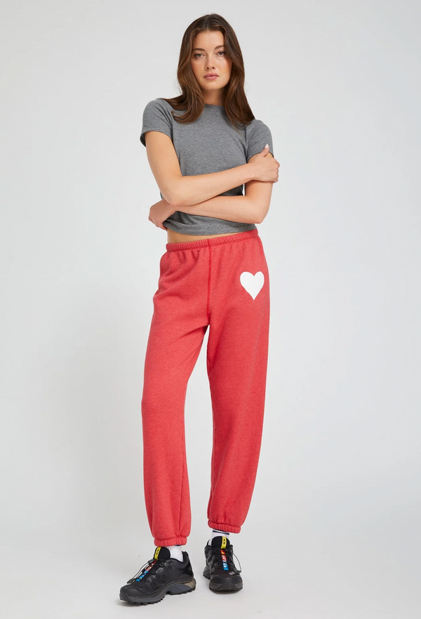 Woman wearing a gray t-shirt and red sweatpants with a heart design on a white background