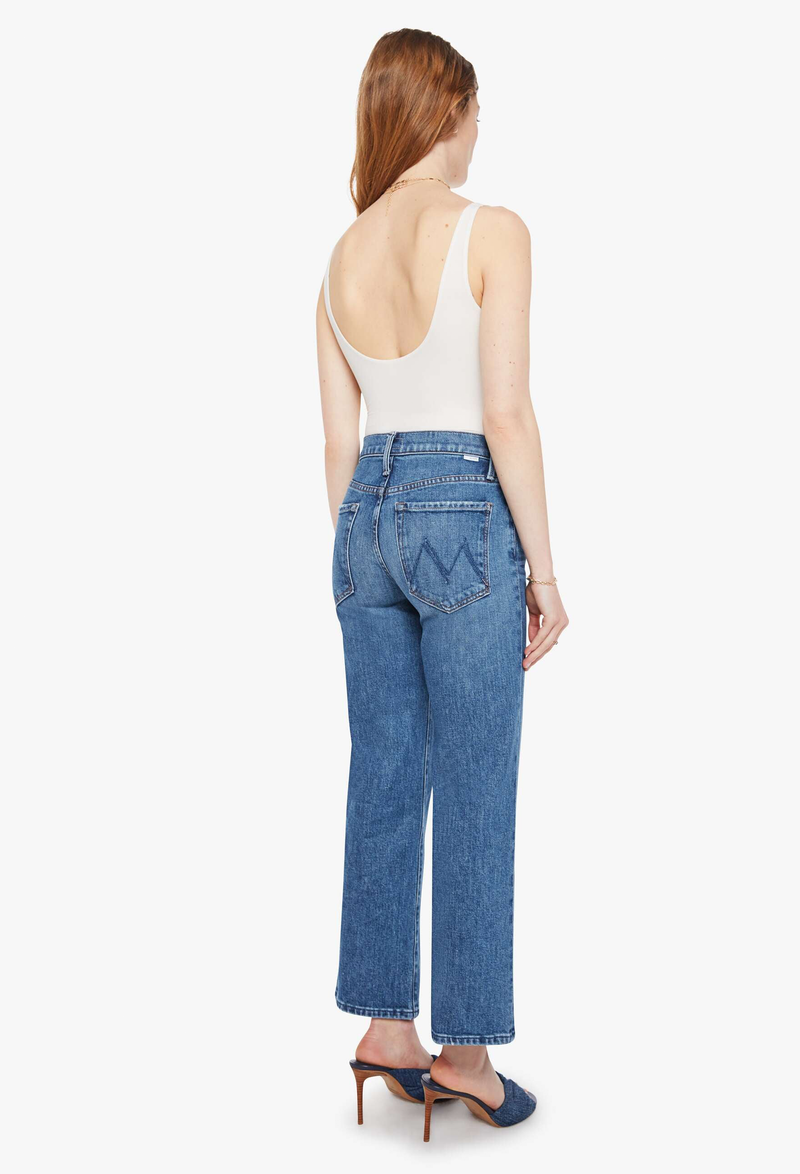 Woman wearing blue jeans and a white top on a white background