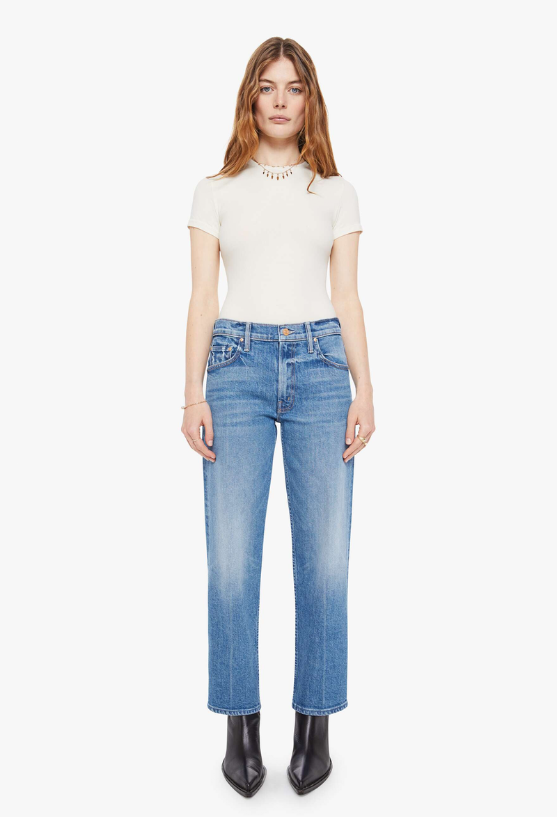 Woman wearing a white top and blue jeans on a white background