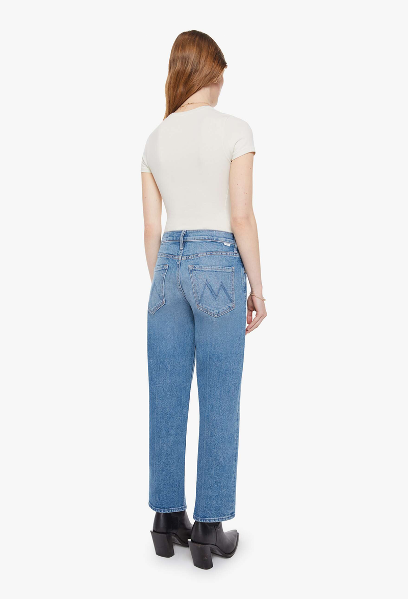 Woman wearing blue jeans and a white top on a white background