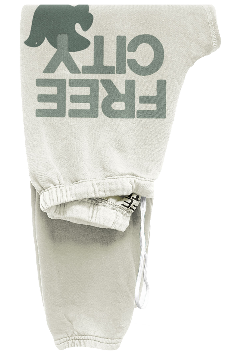 off white sweatpants with green 'free city' text and dove graphic on a white background