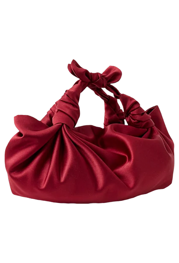 Red satin handbag with a knotted design on a white background