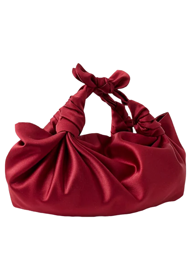 Red satin handbag with a knotted design on a white background