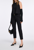 woman wearing a black top and black pants on a white background