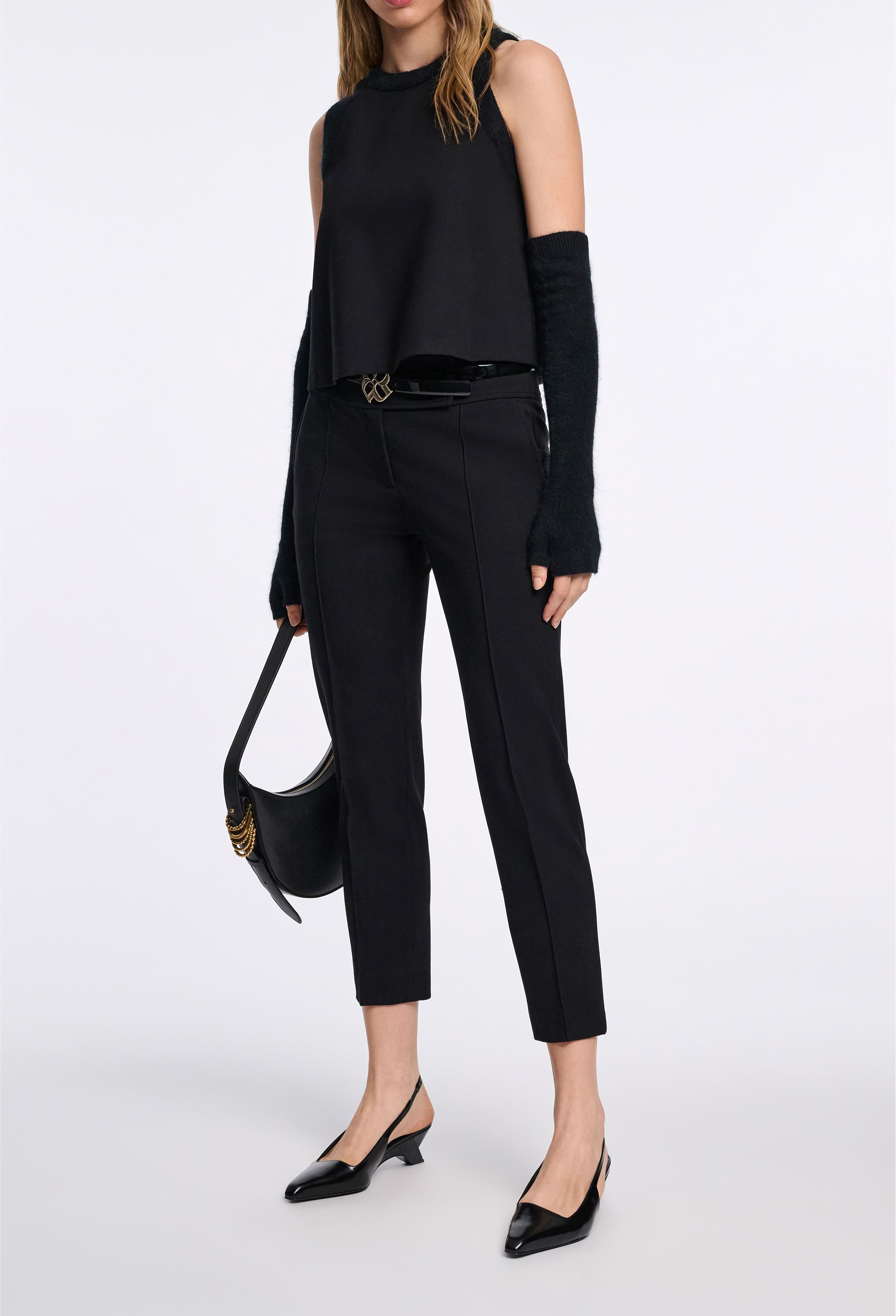 woman wearing a black top and black pants on a white background