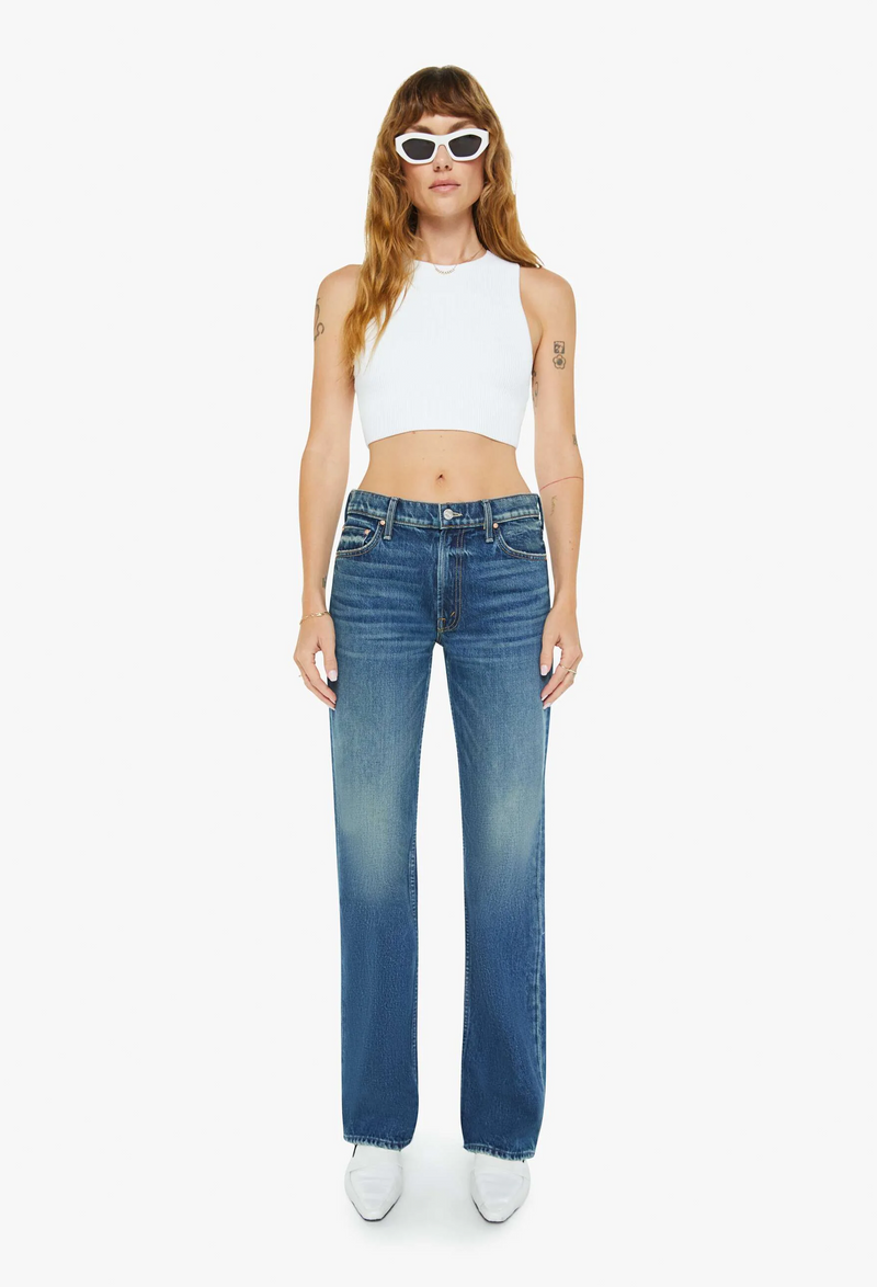 Woman wearing blue jeans and a white top on a white background