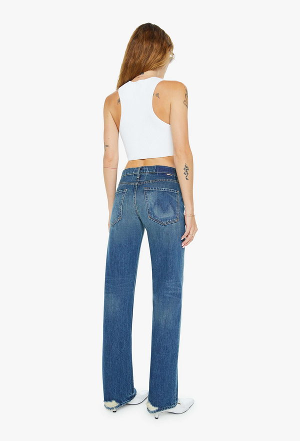 Woman wearing blue jeans and a white top on a white background