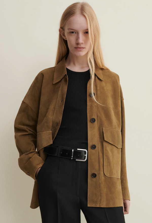 Person wearing a brown jacket with a plain background