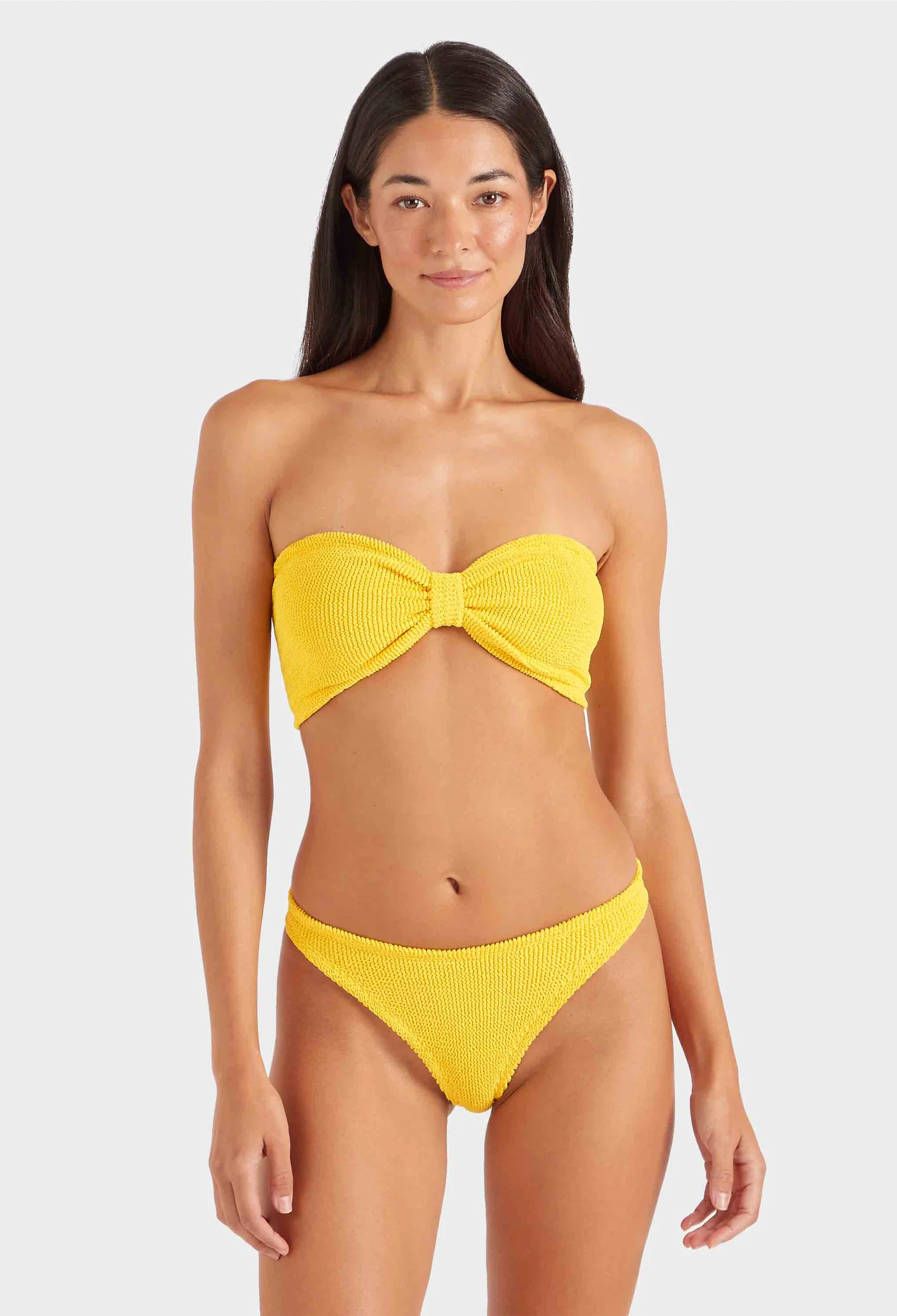 a woman wearing a yellow strapless bikini on a white background
