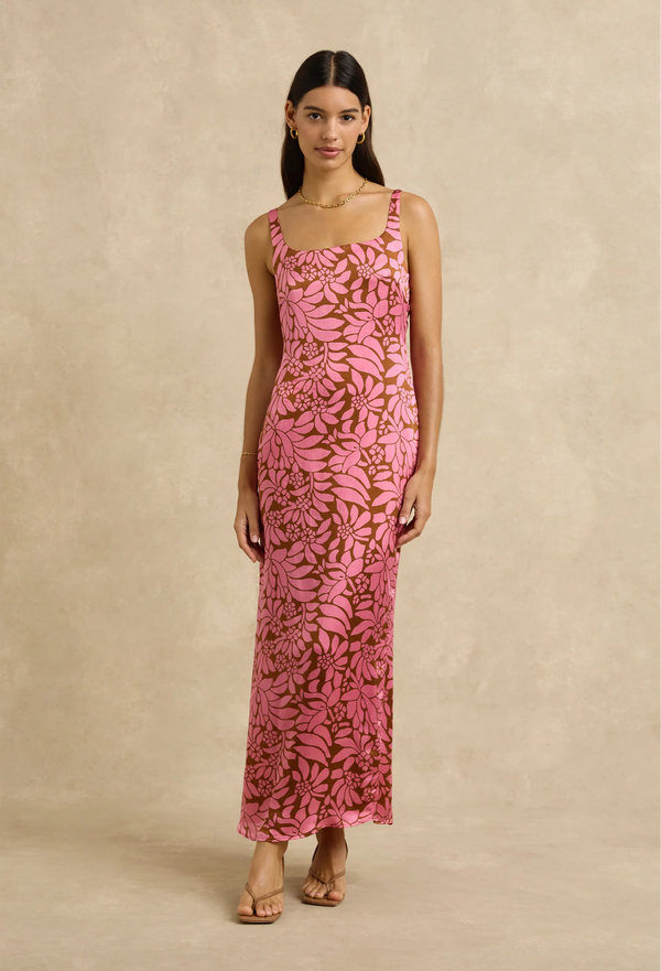 Woman wearing a pink floral dress against a beige background