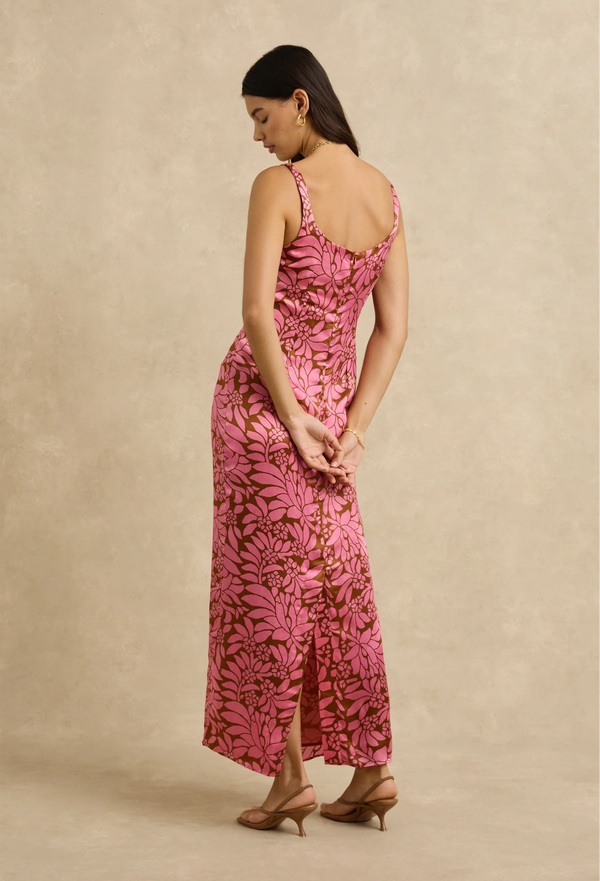 Woman wearing a pink floral dress against a beige background