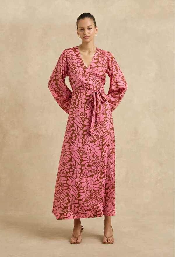 Woman wearing a pink floral dress against a beige background