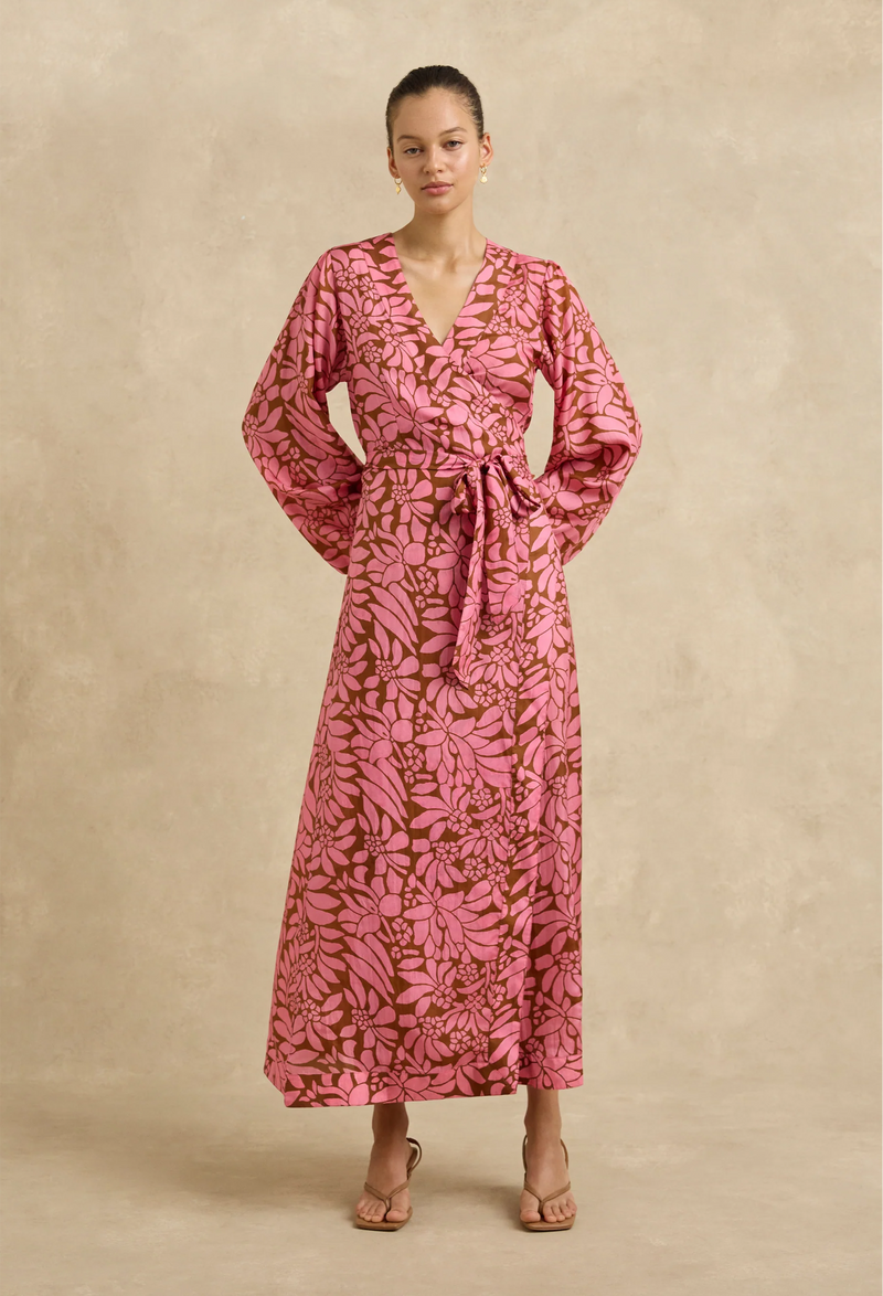 Woman wearing a pink floral dress against a beige background