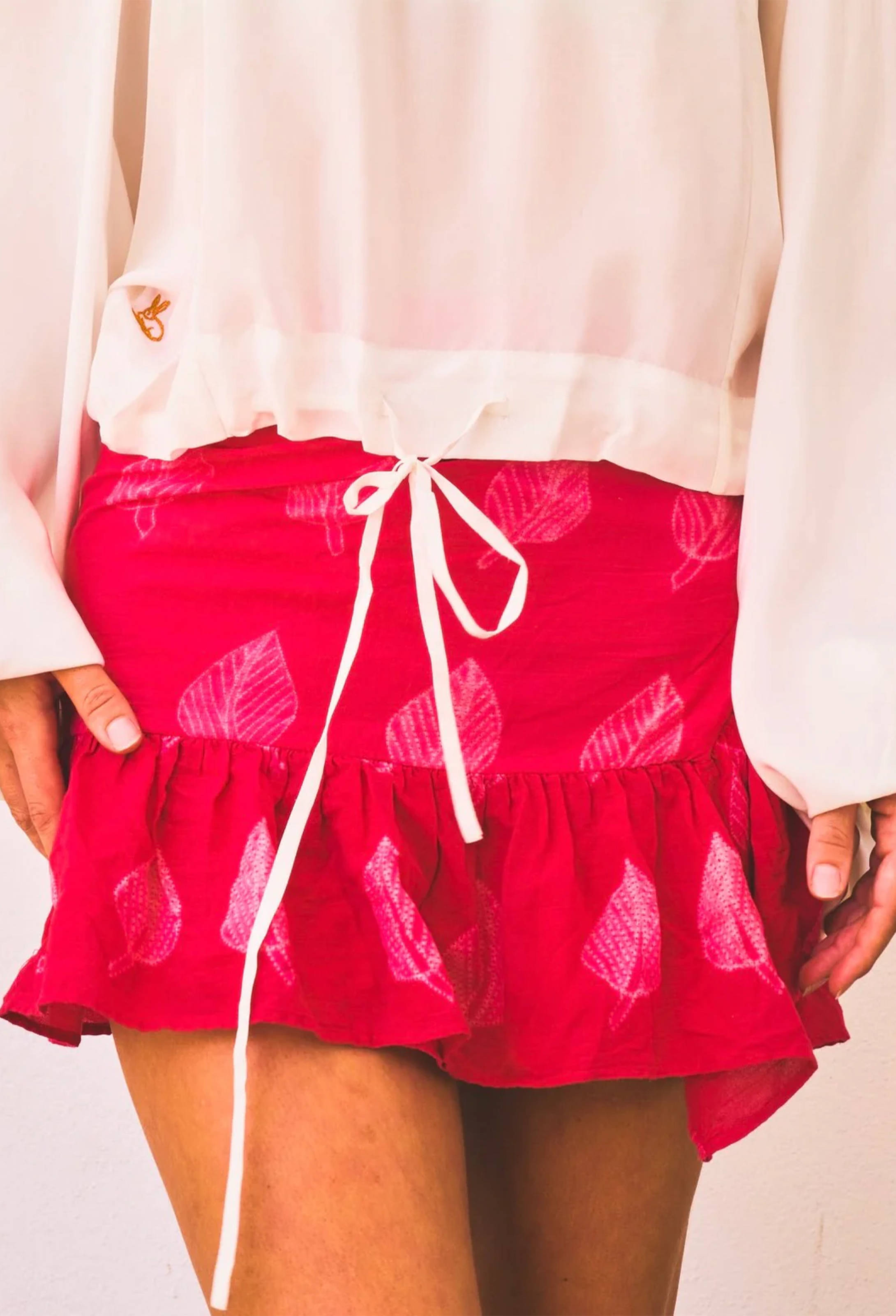 Red skirt with white leaf pattern and drawstring on a plain background