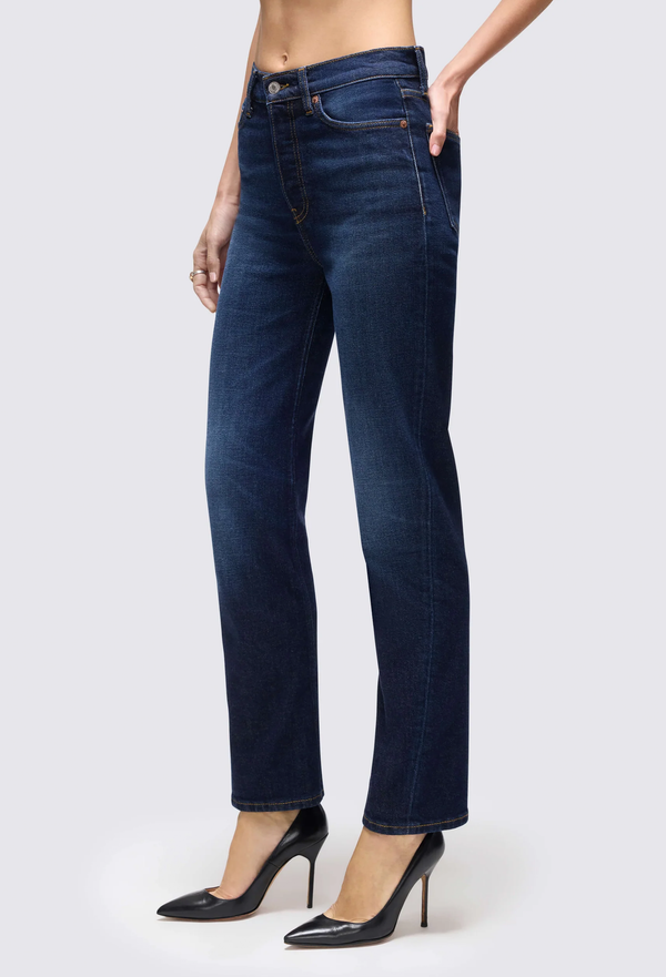 a model wearing dark blue jeans on a white background