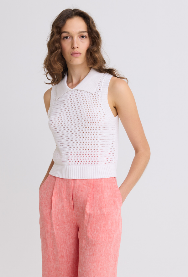 a model wearing a white mesh knit collared tank top on a white background