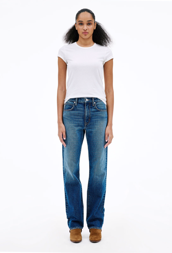 Woman wearing blue jeans and a white t-shirt on a white background