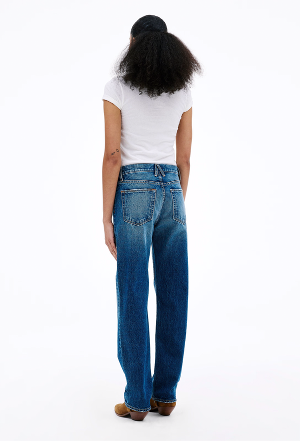Person wearing blue jeans and a white t-shirt on a white background