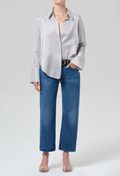 Person wearing a striped shirt and blue jeans on a white background