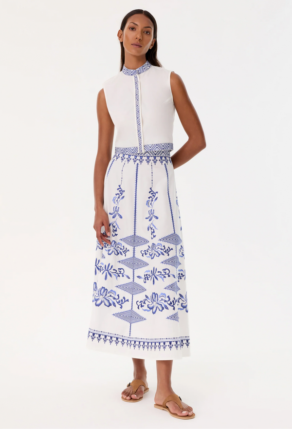 Woman wearing a white skirt with blue patterns on a white background