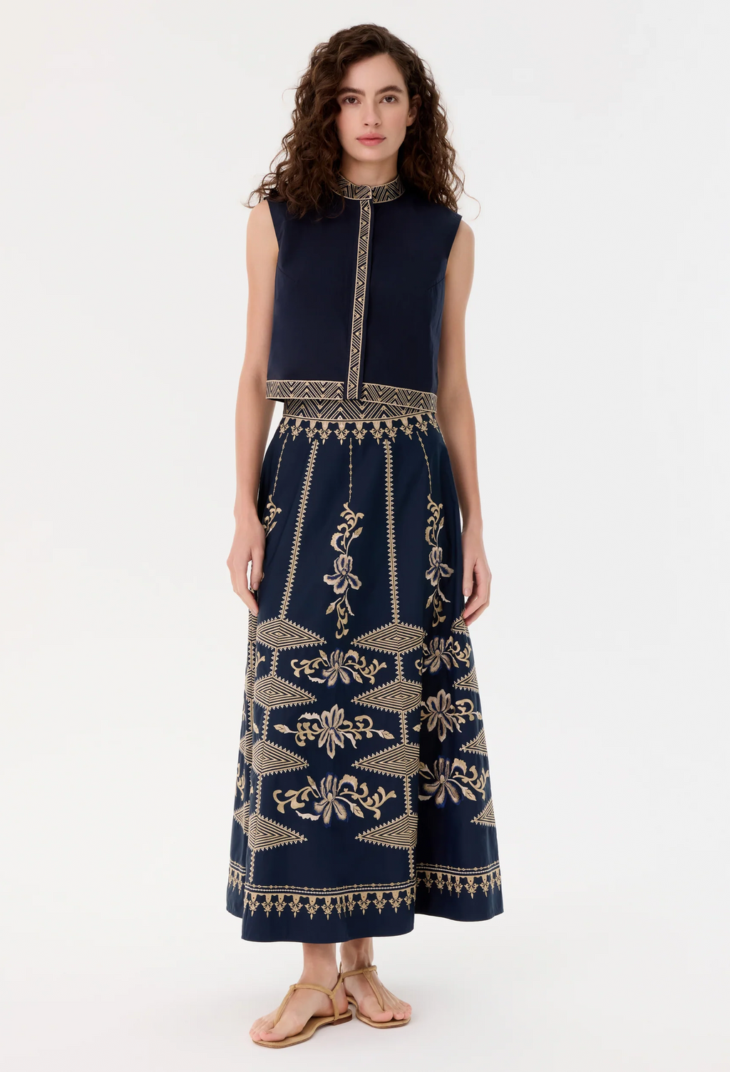Woman wearing a blue skirt with gold patterns on a white background