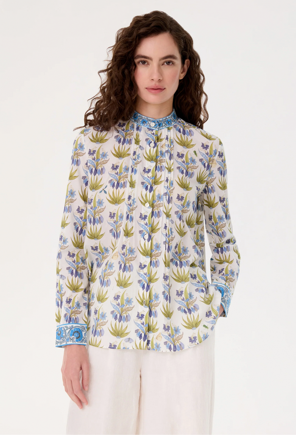 Woman wearing a floral patterned blouse against a white background